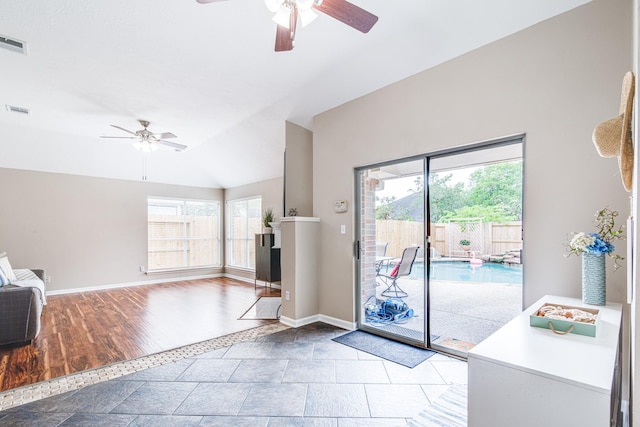 doorway to outside with visible vents, a ceiling fan, high vaulted ceiling, and baseboards