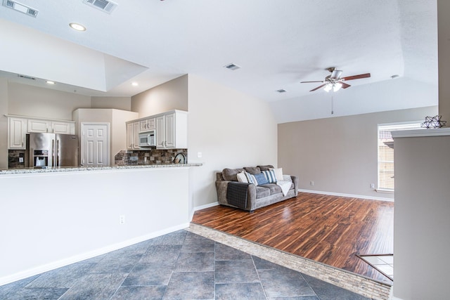 living area with visible vents, ceiling fan, and baseboards