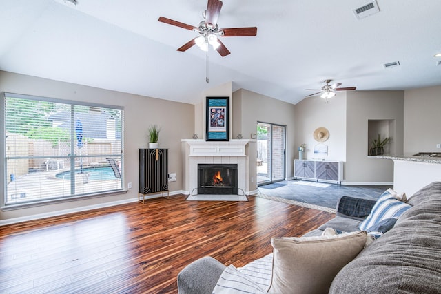 living room featuring visible vents, wood finished floors, a ceiling fan, and vaulted ceiling