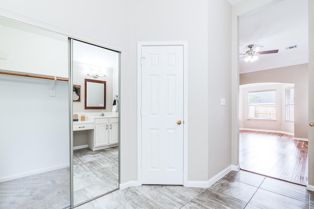 hallway with ornamental molding, visible vents, and baseboards
