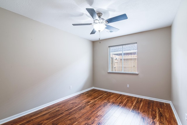 empty room featuring visible vents, ceiling fan, wood finished floors, and baseboards