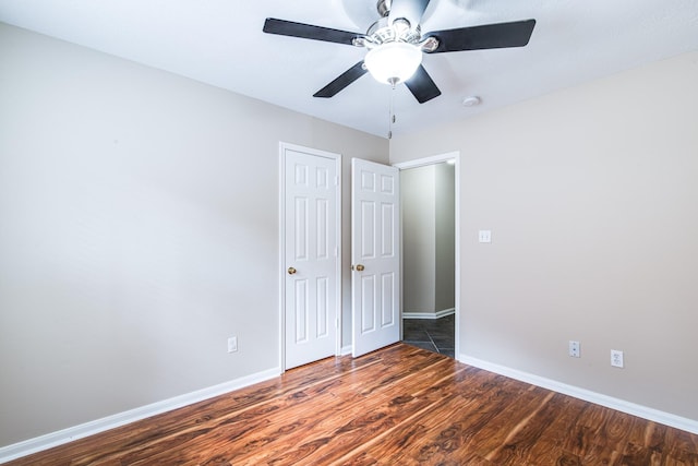 unfurnished bedroom featuring a ceiling fan, wood finished floors, and baseboards