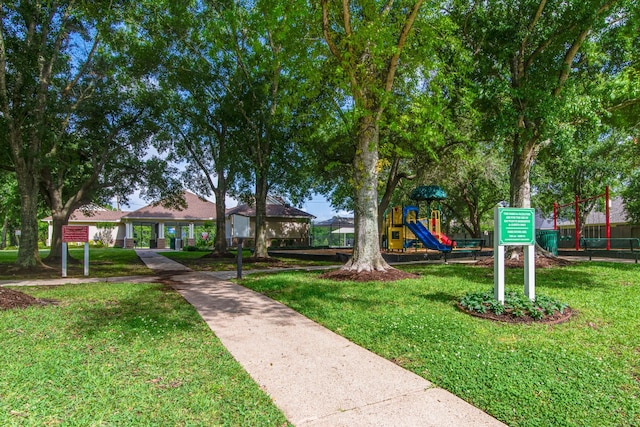 view of home's community featuring playground community and a yard