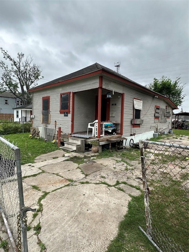 rear view of house with fence and a porch