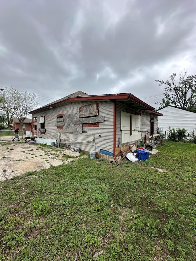 view of property exterior with fence and a lawn