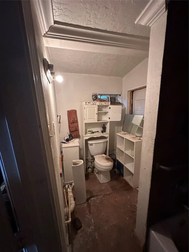 bathroom featuring concrete flooring, toilet, and a textured ceiling