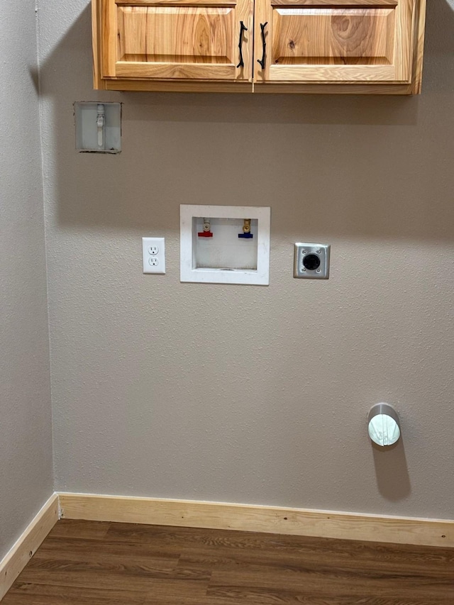 washroom featuring hookup for a washing machine, electric dryer hookup, cabinet space, baseboards, and dark wood-type flooring