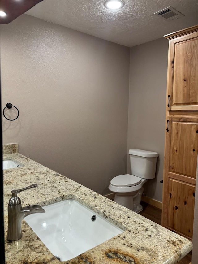 bathroom with a sink, visible vents, toilet, recessed lighting, and wood finished floors