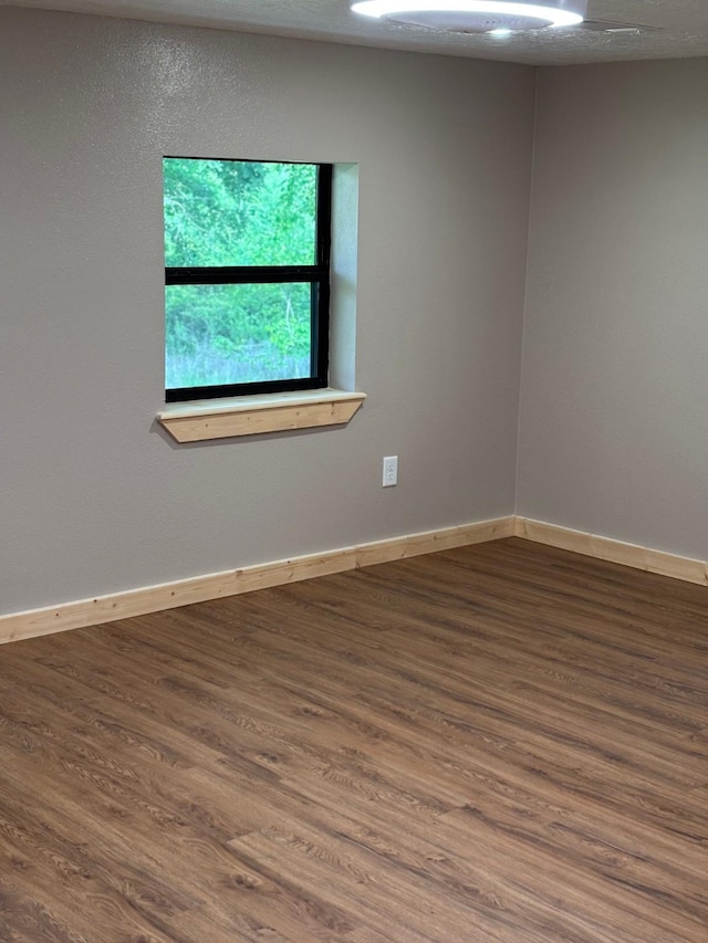 unfurnished room featuring baseboards and wood finished floors