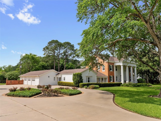 greek revival house with a front yard and concrete driveway