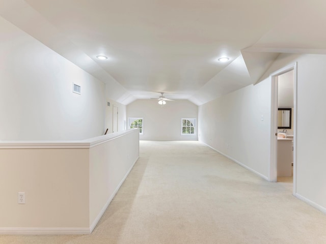 hallway featuring recessed lighting, light carpet, baseboards, visible vents, and lofted ceiling