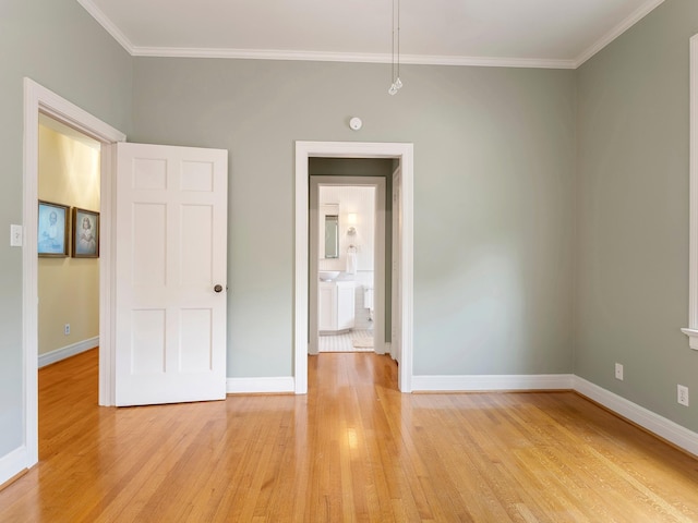 unfurnished bedroom with crown molding, light wood finished floors, and baseboards
