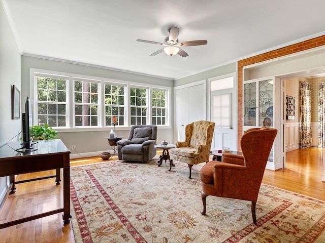 interior space featuring wood finished floors, a ceiling fan, and crown molding