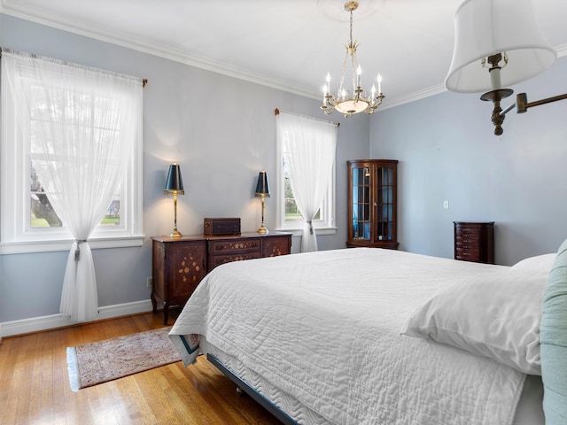 bedroom featuring a chandelier, baseboards, hardwood / wood-style flooring, and multiple windows