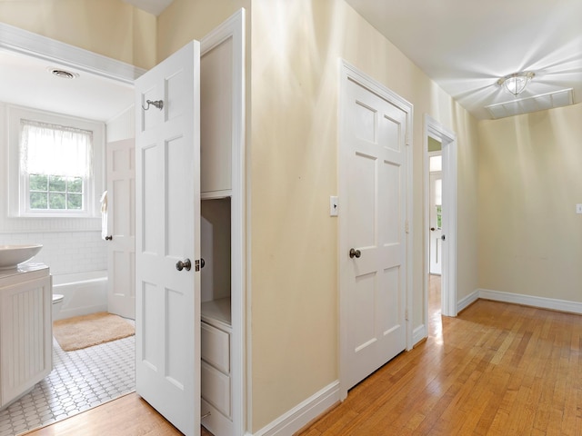 interior space featuring visible vents, light wood finished floors, and baseboards