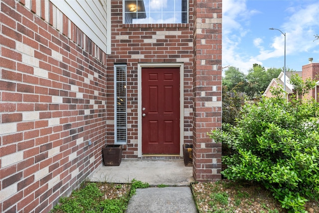 entrance to property featuring brick siding