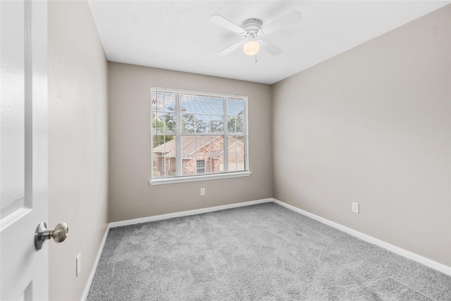 carpeted spare room with ceiling fan and baseboards
