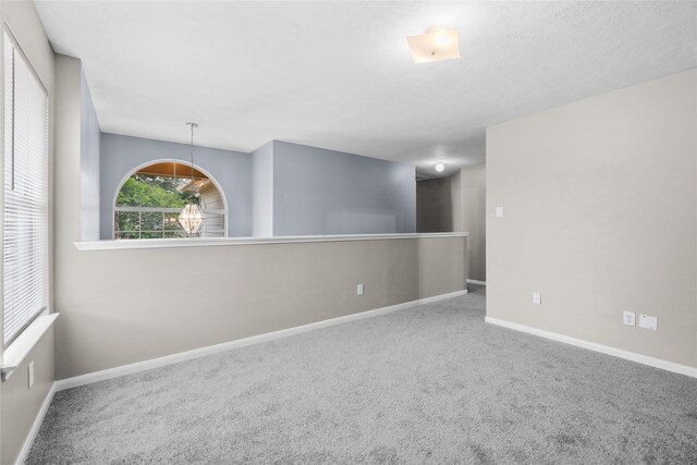 carpeted empty room with baseboards