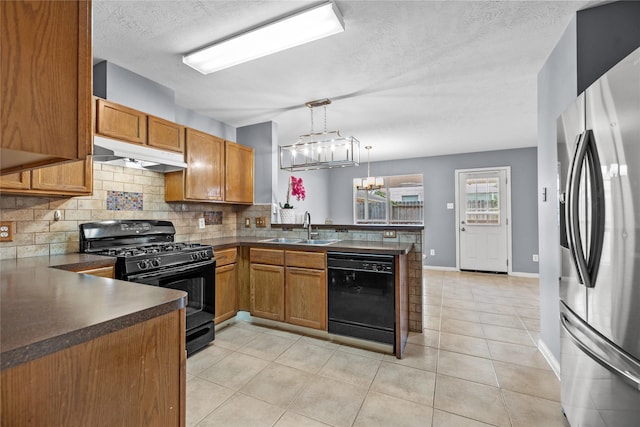 kitchen featuring black appliances, dark countertops, under cabinet range hood, and a sink