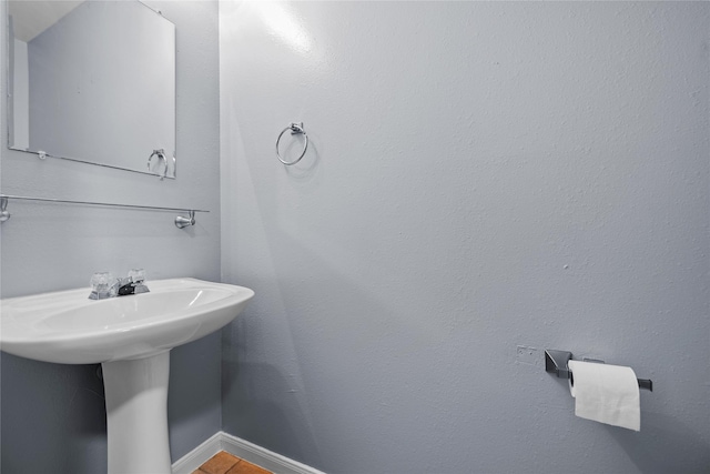 bathroom featuring a sink and baseboards
