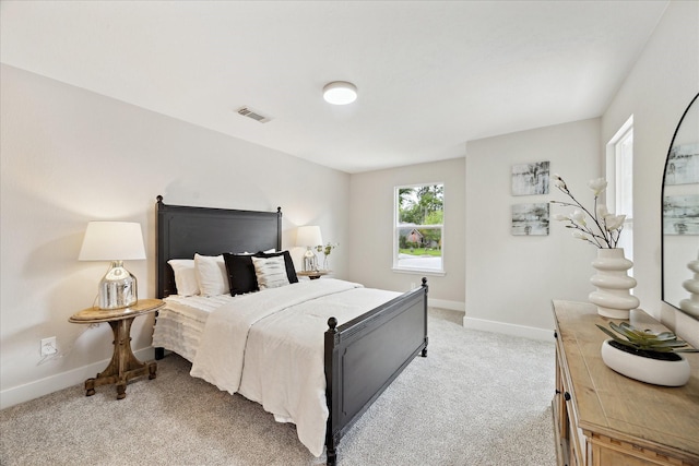 bedroom featuring baseboards, light carpet, and visible vents