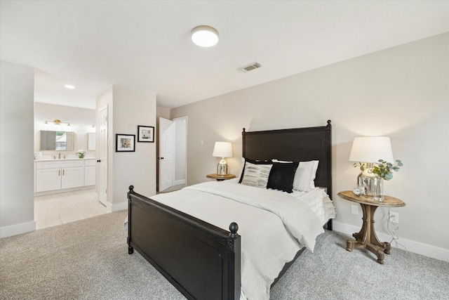 bedroom featuring light colored carpet, connected bathroom, baseboards, and visible vents