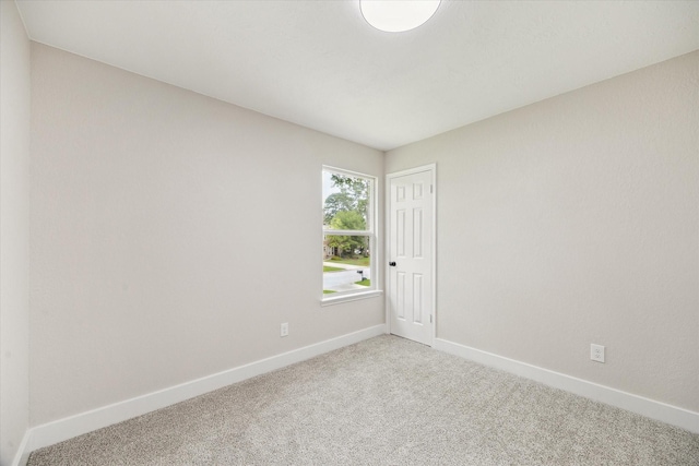 carpeted empty room with baseboards