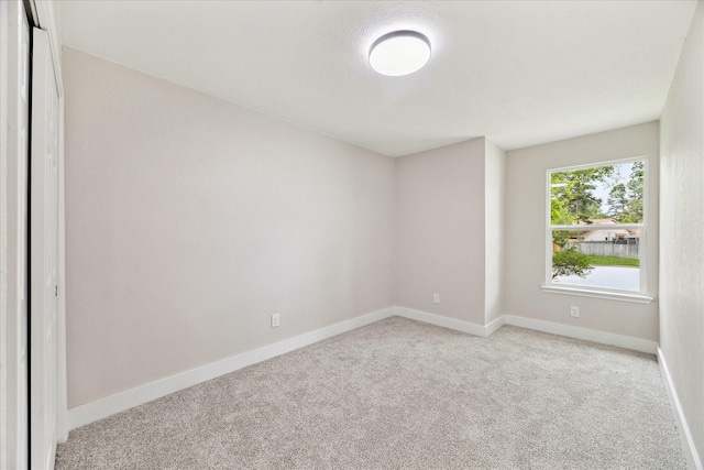 carpeted spare room with baseboards