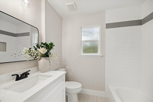 bathroom featuring visible vents, vanity, baseboards, toilet, and tub / shower combination