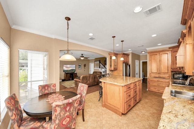 kitchen with a ceiling fan, visible vents, arched walkways, a sink, and freestanding refrigerator