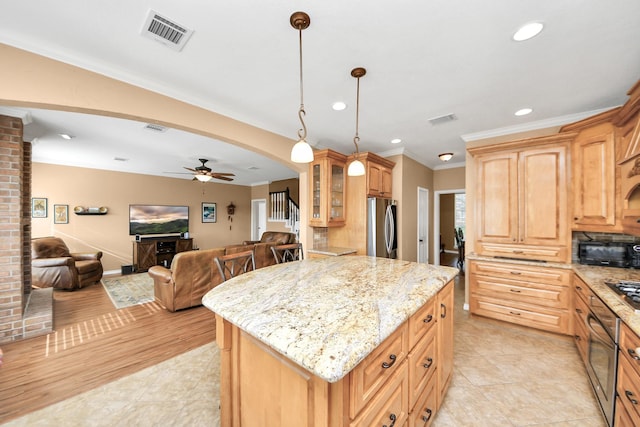 kitchen with visible vents, open floor plan, appliances with stainless steel finishes, and ceiling fan