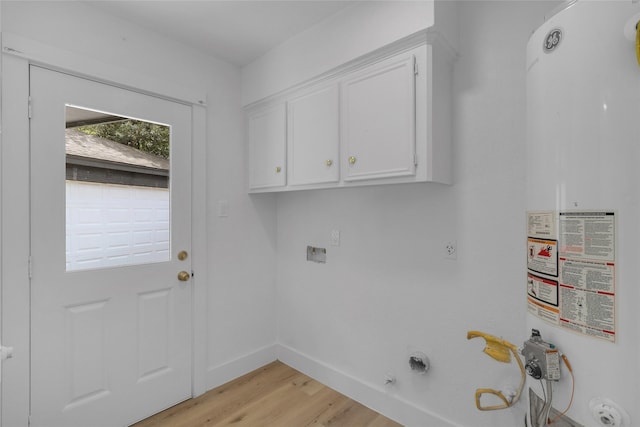 laundry area with cabinet space, hookup for an electric dryer, hookup for a gas dryer, gas water heater, and light wood finished floors