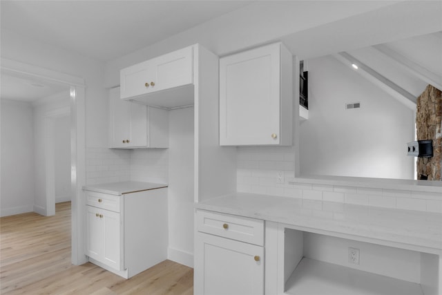 kitchen featuring decorative backsplash, light wood-style floors, visible vents, white cabinetry, and baseboards