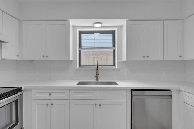 kitchen featuring white cabinets, appliances with stainless steel finishes, light countertops, and a sink