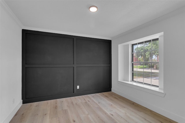 unfurnished bedroom with baseboards, ornamental molding, and wood finished floors