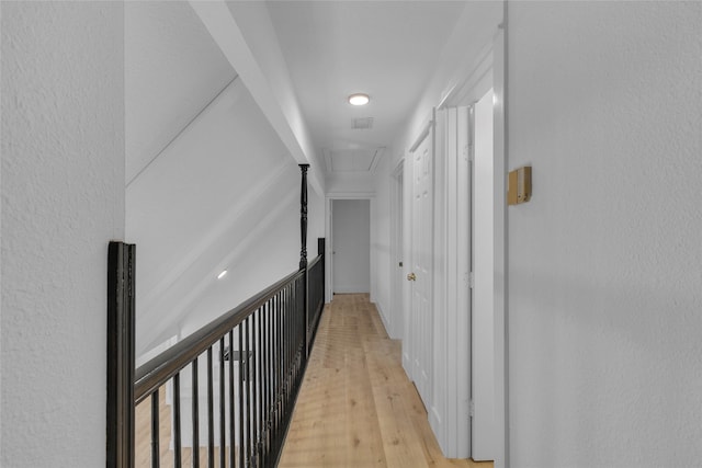 hall featuring attic access and light wood finished floors