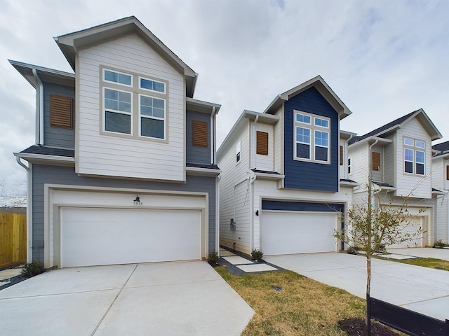 view of front of home featuring fence, concrete driveway, and a garage