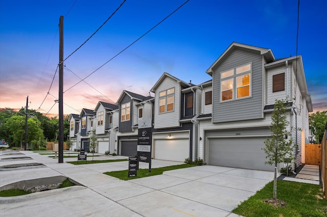 townhome / multi-family property with a residential view, driveway, an attached garage, and fence