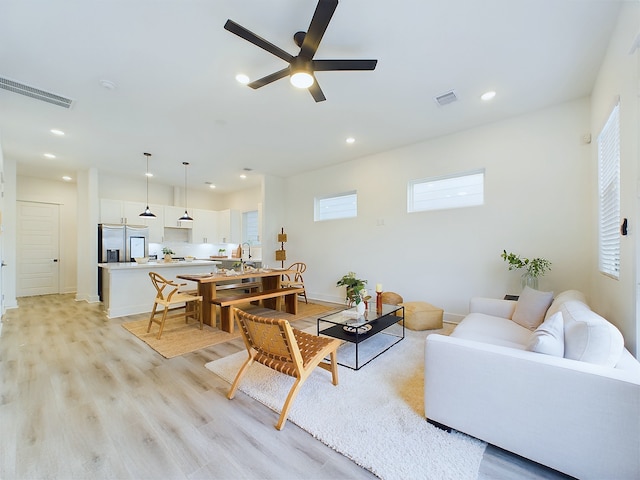 living area with recessed lighting, a ceiling fan, visible vents, and light wood finished floors