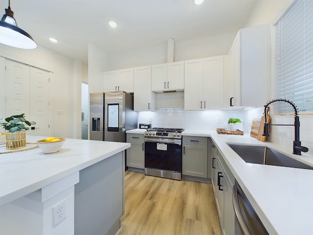 kitchen featuring a sink, appliances with stainless steel finishes, light wood-type flooring, recessed lighting, and gray cabinets