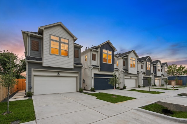 view of front facade with driveway, fence, a residential view, and a garage