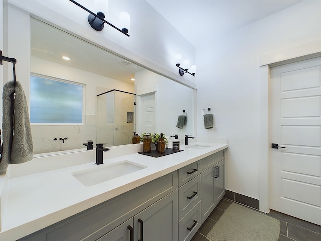 bathroom with tile patterned floors, double vanity, a stall shower, and a sink