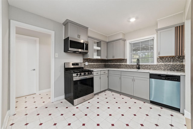 4517 W 43rd St, Houston, TX 77092 - kitchen featuring light floors, decorative backsplash, stainless steel appliances, a sink, and gray cabinetry