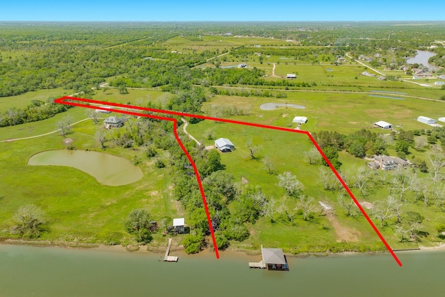 drone / aerial view with a forest view and a water view