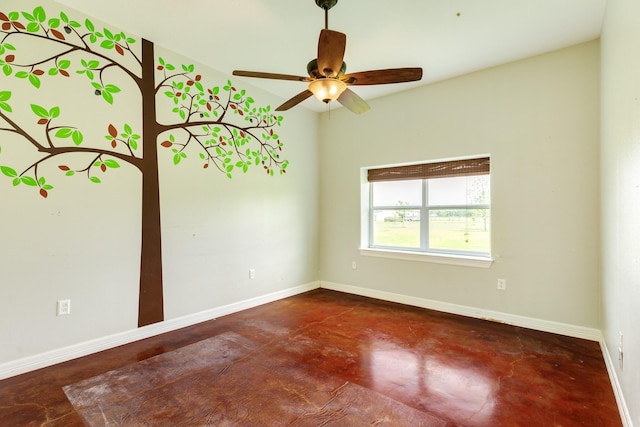 spare room with a ceiling fan, concrete flooring, and baseboards