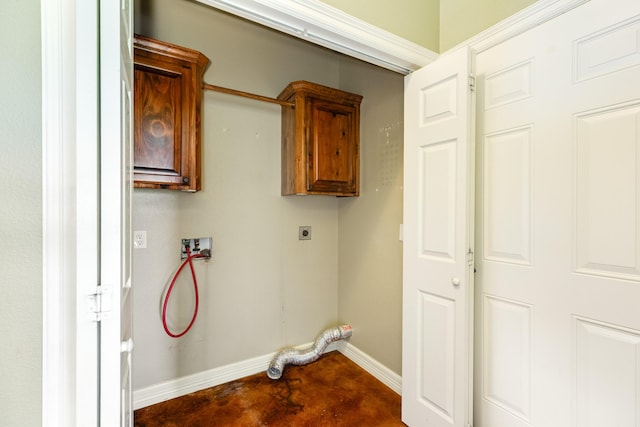 clothes washing area featuring electric dryer hookup, cabinet space, hookup for a washing machine, and baseboards