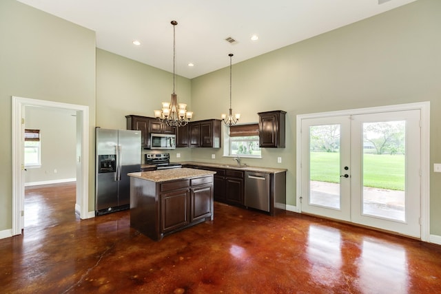 kitchen featuring concrete flooring, stainless steel appliances, high vaulted ceiling, and a notable chandelier