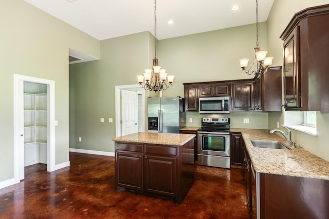 kitchen featuring concrete flooring, stainless steel appliances, a notable chandelier, and a sink