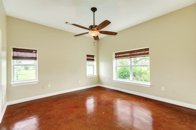 empty room with baseboards, a ceiling fan, and concrete floors
