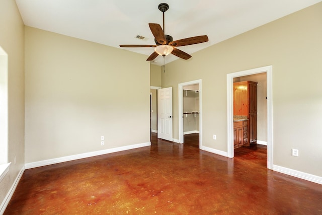 unfurnished bedroom featuring a closet, visible vents, baseboards, finished concrete floors, and a spacious closet